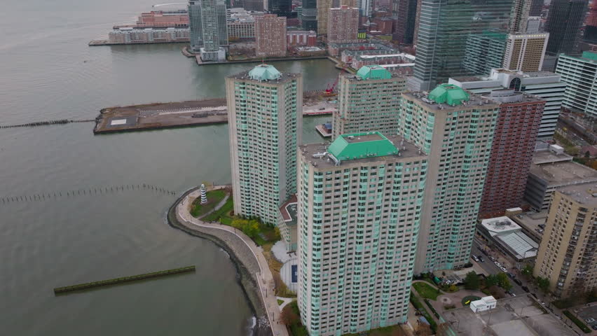 Panoramic drone view revealing Jersey City skyline, waterfront expanse with residential buildings and modern corporate skyscrapers