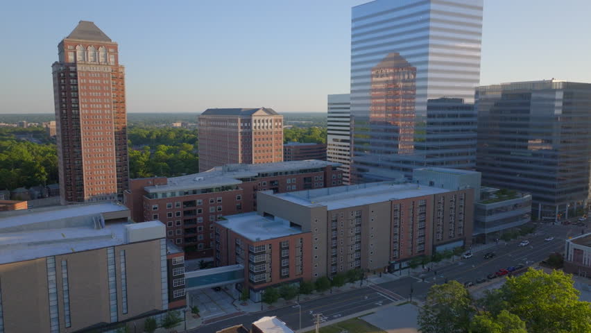 Aerial shot pushing toward modern condos and city buildings in Clayton, St. Louis, Missouri, on a clear and beautiful day. A dynamic urban scene