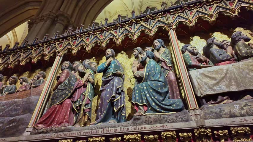 Detailed religious stone carvings inside the historic Notre Dame cathedral wall depicting biblical scenes, Paris, France.