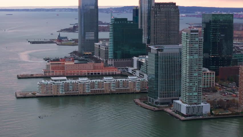 Purple sunset illuminating Exchange Place skyline, gleaming skyscrapers reflecting over Hudson River waters in Jersey City landscape