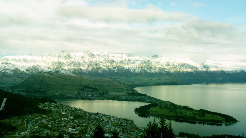 Queenstown lakeside town surrounded by snow cap mountains in New Zealand Time Lapse.