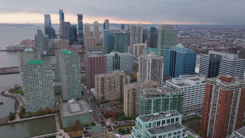 Aerial view of Jersey City skyline at sunset, showcasing modern buildings, urban landscape, and the waterfront area