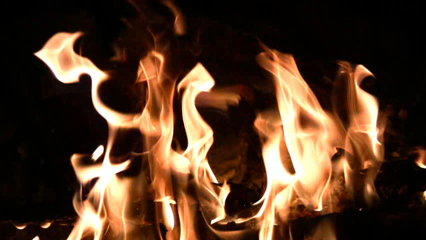 Bonfire lit in the dark. The flames create a variety of intricate patterns.