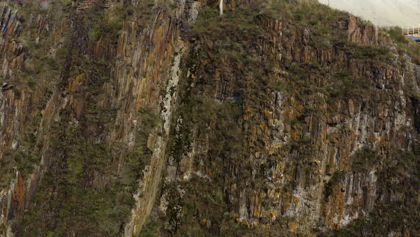 Drone tilt-up shot of ancient stone watchtower on top of mountain in Sioni village, Georgia, showcasing rugged terrain and vast surrounding landscape.