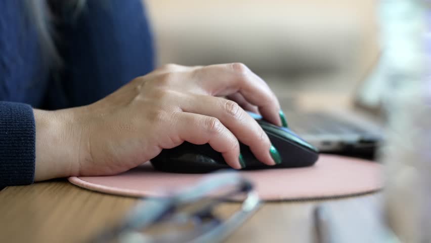 Woman Using Mouse on Surface, Laptop and Desk, Modern Work Environment Detail