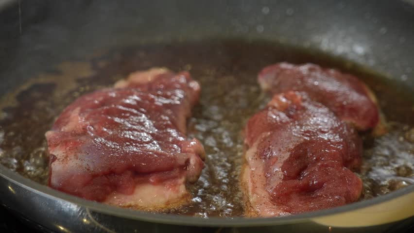 Frying raw duck breast on a hot frying pan