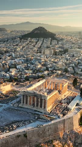Aerial view of Athens, Greece at sunrise, showcasing Acropolis and surrounding city. Fly over Parthenon in Athens in the morning, Ancient Greece landmark. Vertical shot
