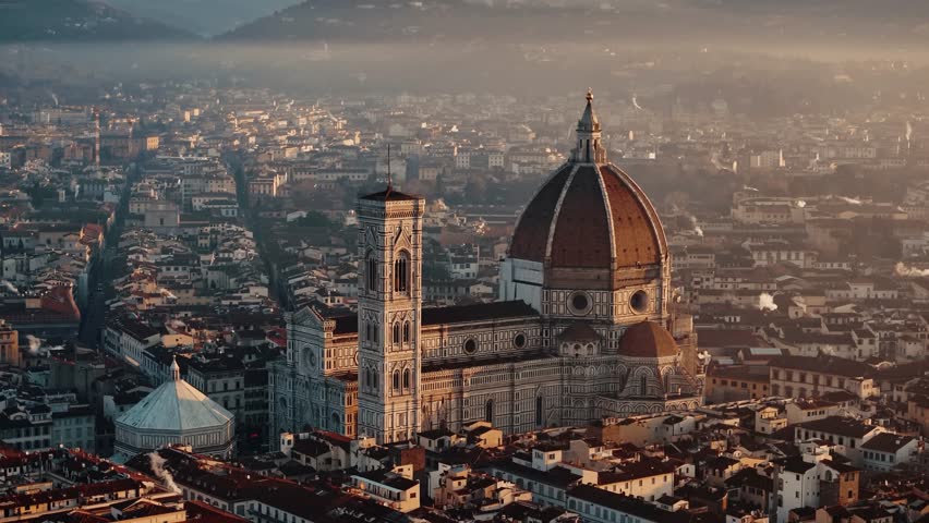 Aerial establishing approach to Florence Duomo at sunrise, golden light over the city rooftops