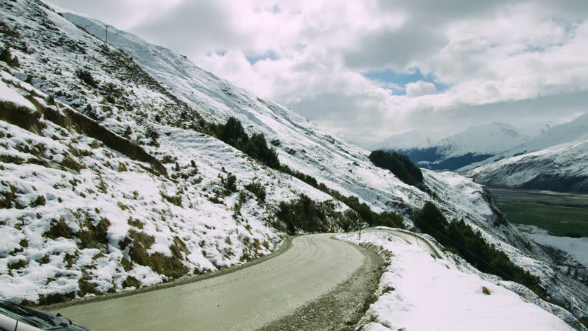 Snow mountains surrounding Wanaka Lake in New Zealand panning shot.