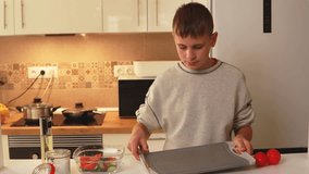 Teenage chef preparing fresh salad, precisely cutting ripe tomatoes and adding sliced cucumbers into clear glass bowl within modern kitchen setting - Powered by Shutterstock - Get 15% off with code: PIKWIZARD15