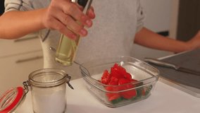Young chef chopping fresh tomatoes, cucumber, drizzling olive oil, seasoning homemade salad in bright, sunlit kitchen with wooden cutting board - Powered by Shutterstock - Get 15% off with code: PIKWIZARD15