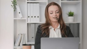 A professional woman participates in a virtual meeting with a headset, seated at her desk, engaged in her work, surrounded by documents and office plants that enhance her productivity - Powered by Shutterstock - Get 15% off with code: PIKWIZARD15