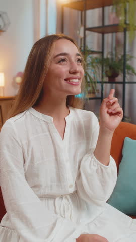 Eureka. Thoughtful clever inspired woman make gesture raises finger came up with creative plan feels excited with good idea inspiration motivation question at apartment. Girl sits on couch. Vertical