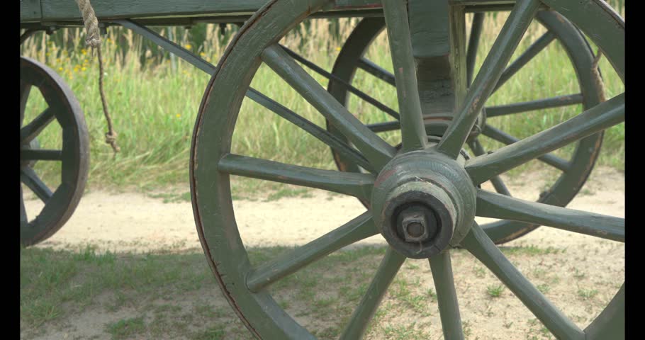 Country horse carriage used in the 19th century. The cart for agricultural work. Vintage wagon wooden wheel in green grass. 
