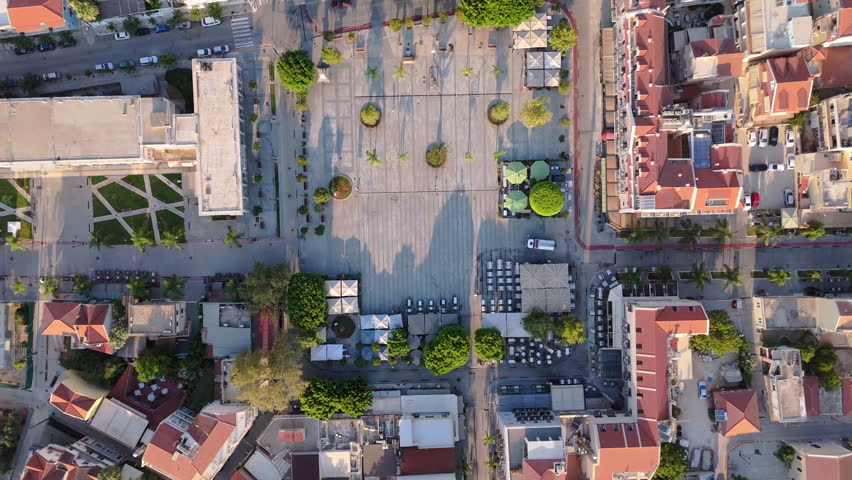 Drone top down over public market square in Argostoli, Kefalonia, Greece, streets, buildings, and urban layout, establishing ascend