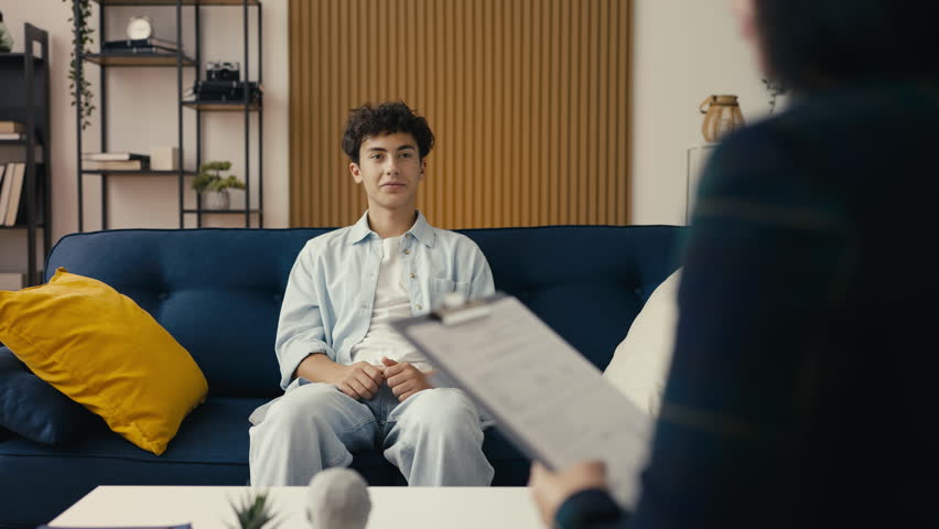 Happy teenager sharing positive news with a psychologist, successful therapy