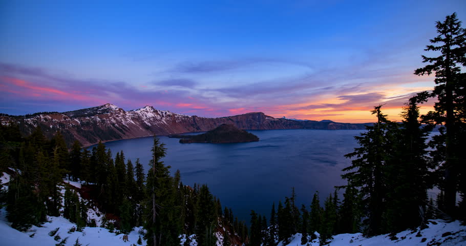 Time Lapse Lockdown Shot Of Dramatic Clouds Over Lake And Snowy Mountains In National Park - Crater Lake, Oregon