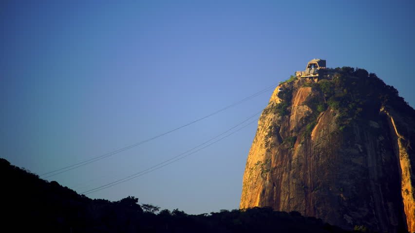 Lockdown Shot Of Overhead Cable Cars Moving On Sugarloaf Mountain Against Clear Sky - Rio de Janeiro, Brazil