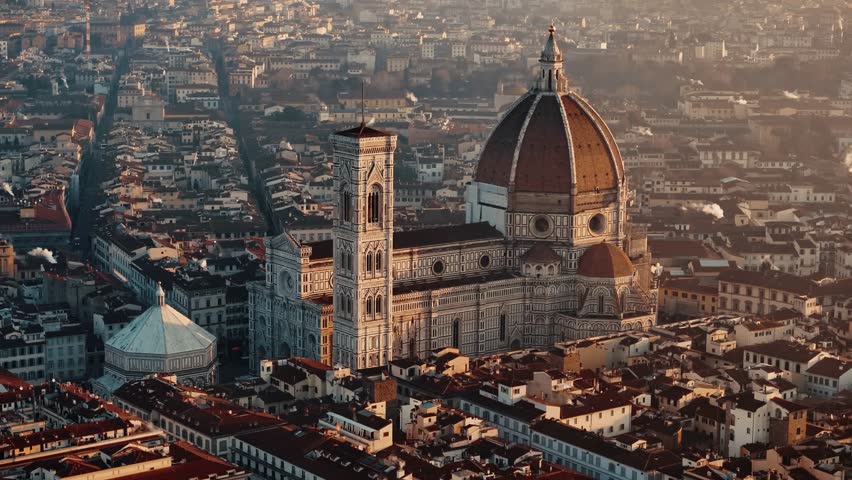 Aerial retreating descend pan up over Florence Duomo, revealing the grand cityscape and warm morning light