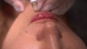 Beautician doctor makes botox injection in the lips of young beautiful woman. Colorcorrected 4k shot - Powered by Shutterstock - Get 15% off with code: PIKWIZARD15