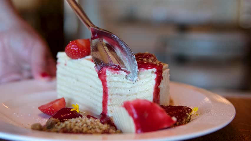 thin cakes with cream white cake thin cakes many layers with strawberry jam eat with a spoon from a white plate thin pancakes smeared with cream for breakfast