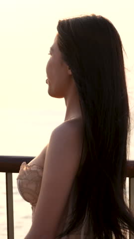 Brunette model posing sunset sky background portrait. Smiling face of girl looking at camera close-up. Sensual lady spends time in windy weather in the solitude of untouched nature. female model