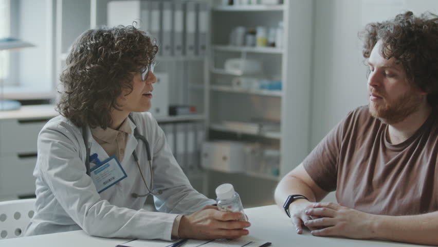 Female doctor explaining dosage of prescribed pills and weight loss plan to obese patient during medical appointment in clinic