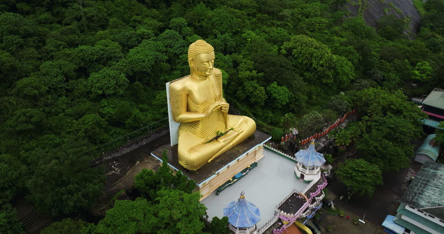 Golden Buddha Statue At Golden Temple of Dambulla In Matale District, Sri Lanka. aerial orbiting shot
