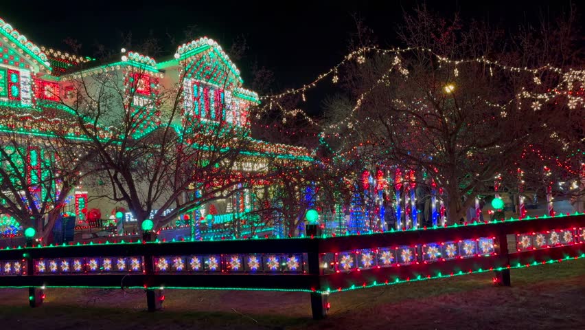 Gingerbread Candy cane lane house vibrant lights home Merry Christmas trees Happy Holidays decoration Highlands Ranch Denver Colorado USA night time bright hanging branch neighborhood left pan motion