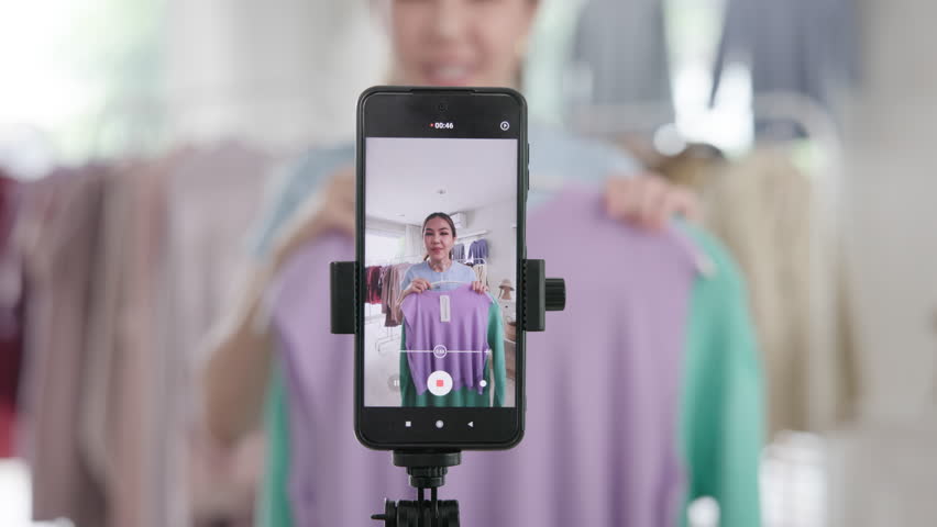 Gen Z vlogger SME owner go green net zero thrift store sale live stream talk on mobile social media online second hand sell. Asia people young woman record home video camera app eco shop side hustle.
