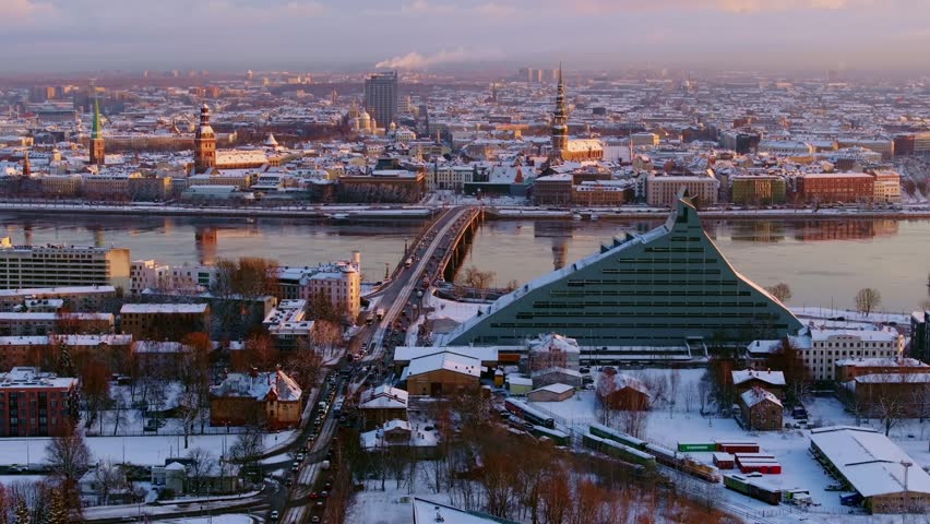 Golden sunrise of Riga cityscape, snowy Europe winter charm, drone, Latvia, 4K