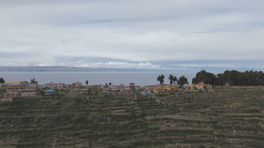 Drone shot above Isla Del Sol near Copacabana Bolivia Titicaca lake on a cloudy day with view on the sea and the islands LOG