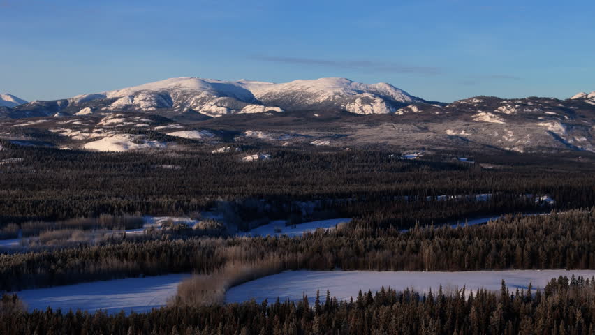 Winter Nature Scene Of Lake Laberge With Forests And Mountain In Yukon, Canada. Aerial Drone Shot