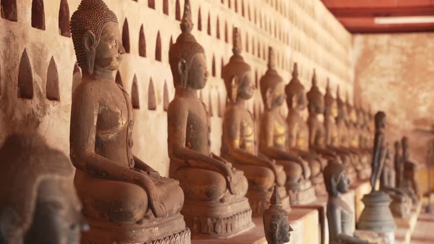Sunlight falls on rows of Buddha statues in Wat Sisaket temple