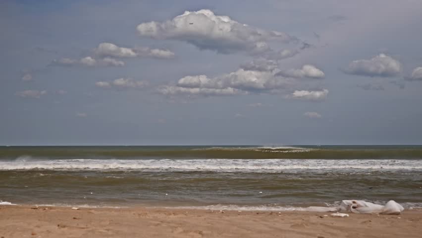 Beach with waves, clouds and in top flying aeroplane at marina beach, chennai, tamil nadu, india. day time, stable shot, 4k.