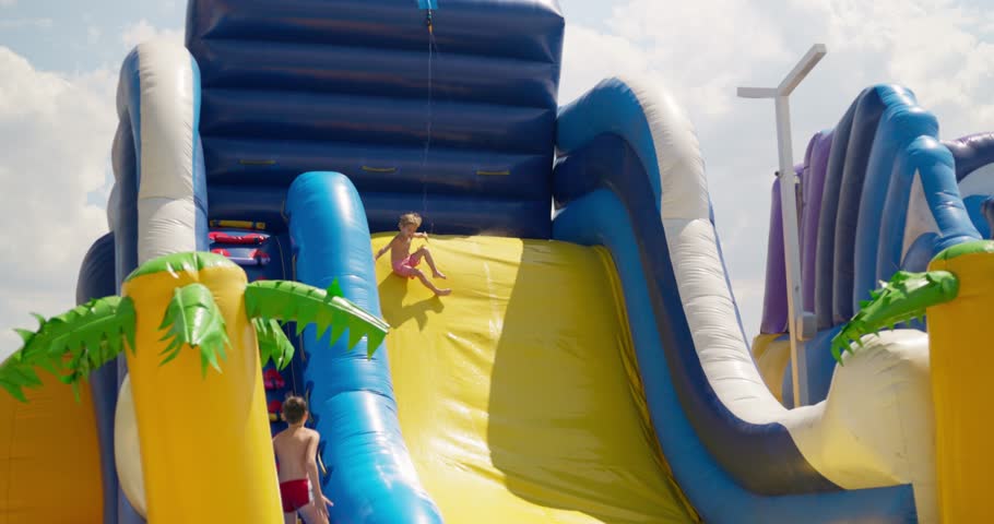 Child Sliding on Colorful Inflatable Water Slide