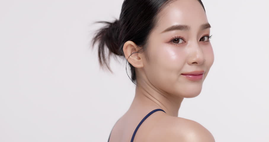 Slow motion of beautiful young Asian girl with glowing skin and k-beauty make up style on isolated white background for commercial beauty advertising.