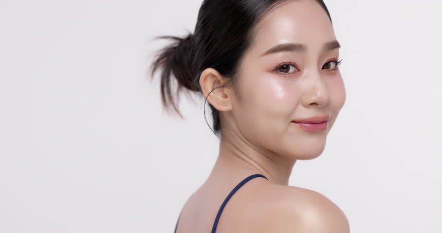 Slow motion of beautiful young Asian girl with glowing skin and k-beauty make up style on isolated white background for commercial beauty advertising.