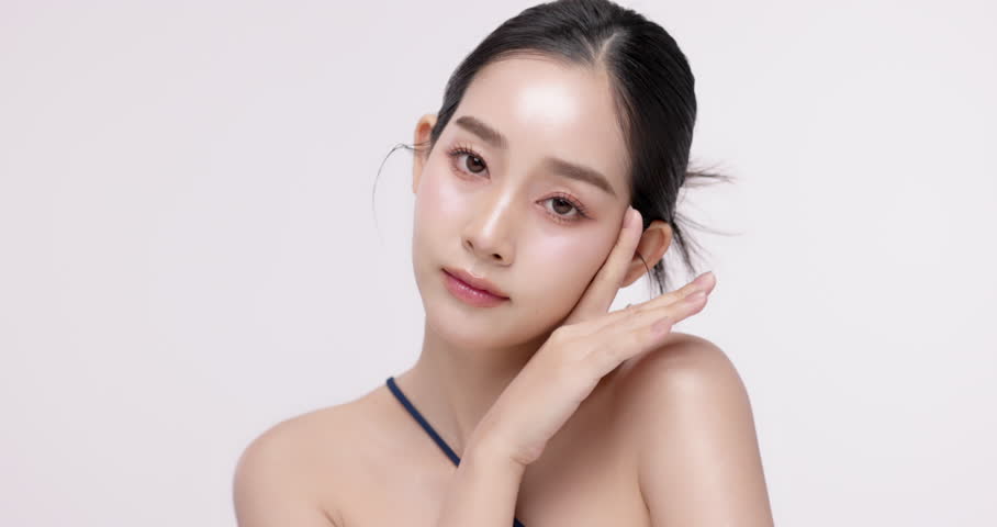 Slow motion of beautiful young Asian girl with glowing skin and k-beauty make up style on isolated white background for commercial beauty advertising.
