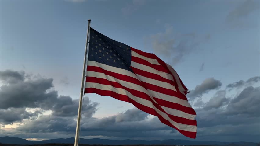Patriotic american flag waving outdoors during windy day. Trump president wins presidential election in 2024. Aerial close up shot.