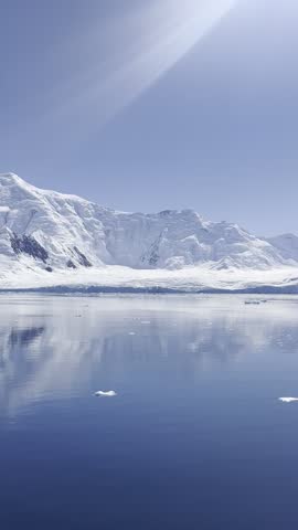 Polar seascape of Antarctica with icebergs floating in the ocean and glacier in the background. Antarctic land on a bright day. It exudes tranquility, with a pristine and untouched polar environment.