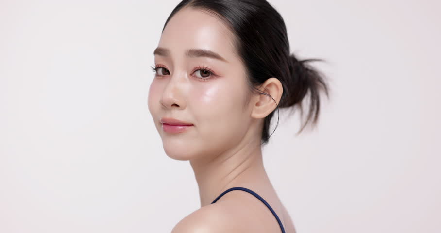 Slow motion of beautiful young Asian girl with glowing skin and k-beauty make up style on isolated white background for commercial beauty advertising.