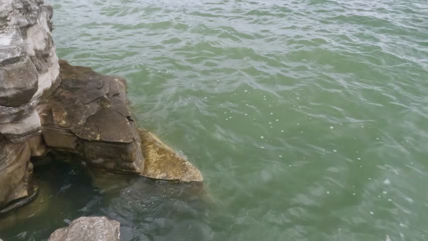 Soft waves crashing against the rocks on the edge of the lake. Feels calm and peaceful for relaxation. Ecological and environmental concepts. .Footage 4K,60Fps