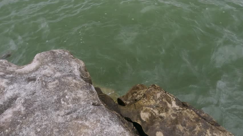 Soft waves crashing against the rocks on the edge of the lake. Feels calm and peaceful for relaxation. Ecological and environmental concepts. .Footage 4K,60Fps