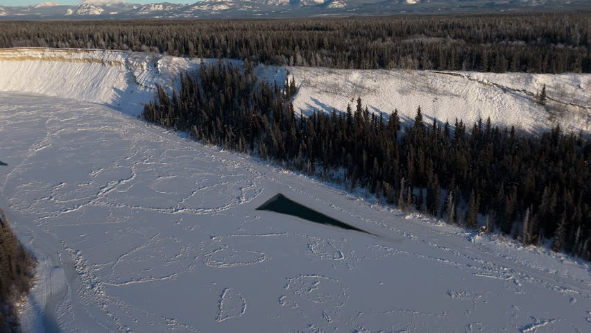 Frozen River During Winter Near Lake Laberge In Whitehorse, Yukon, Canada. Aerial Drone Shot