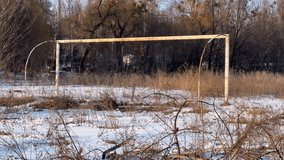 Abandoned Football Goal on Snowy Field with Dry Weeds in Winter Forest Landscape Nostalgic Sport Scene - Powered by Shutterstock - Get 15% off with code: PIKWIZARD15