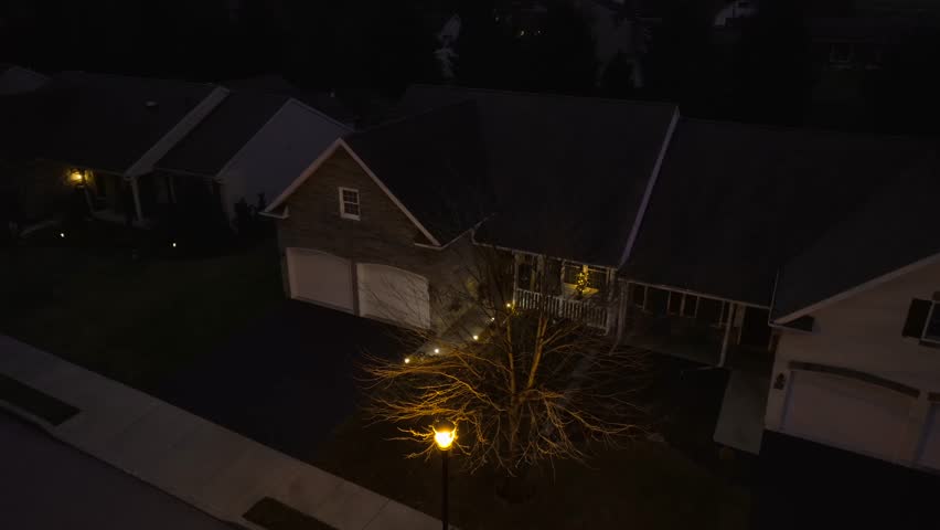 Aerial view of connected homes in retirement development at night. Lit by street light, lamp.