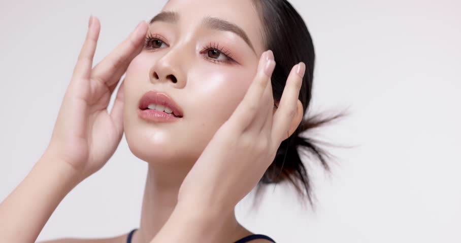 Slow motion of beautiful young Asian girl with glowing skin and k-beauty make up style on isolated white background for commercial beauty advertising.