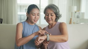 Young adult child give gift AI smart watch IOT app to mature middle age old mum. Love health care older mom asia elder people sit at home sofa happy family wear wrist trace help protect aging life. - Powered by Shutterstock - Get 15% off with code: PIKWIZARD15