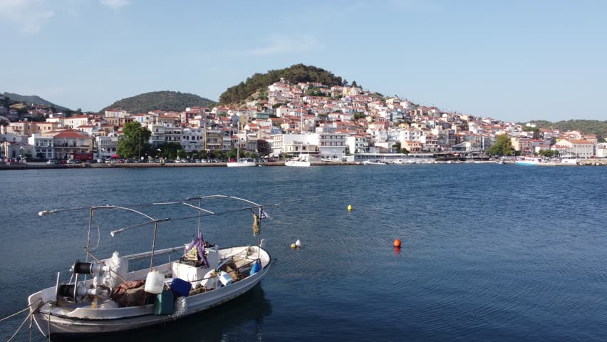 Fishing boat at dock with Plomari town in view, Lesvos Island, Aegean sea, Handheld gimbal shot